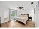 Bright bedroom featuring wood floors, large window and view, and ceiling fan at 525 Gornto Lake Rd, Brandon, FL 33510