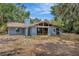 Blue house featuring expansive glass windows, complementing the lush greenery and providing ample natural light at 525 Gornto Lake Rd, Brandon, FL 33510