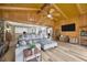 Comfortable living room features wood paneled walls, an exposed beam ceiling and a large couch at 525 Gornto Lake Rd, Brandon, FL 33510