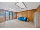 Bright living room with wood paneling, ceiling fan, and large sliding doors offering lake views at 525 Gornto Lake Rd, Brandon, FL 33510