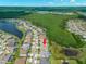 An aerial view shows a home in a Primary-planned community with mature trees, green spaces, and attractive landscaping at 6154 Marsh Trail Dr, Odessa, FL 33556
