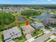 Aerial view of home showcasing tiled roof, three car garage, landscaping, and surrounding neighborhood at 6154 Marsh Trail Dr, Odessa, FL 33556