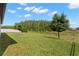 Expansive grassy backyard with mature trees and a serene view of the adjacent treeline at 6154 Marsh Trail Dr, Odessa, FL 33556
