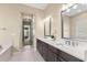 Modern bathroom with dual sinks, granite countertops, tub, walk-in shower, and a view to the exterior at 6154 Marsh Trail Dr, Odessa, FL 33556