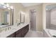 Modern bathroom features double sinks, granite countertops, dark wood cabinetry, and large mirrors at 6154 Marsh Trail Dr, Odessa, FL 33556