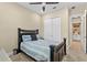 Comfortable bedroom featuring a ceiling fan, a closet, a dark-toned bed with neutral bedding and a view into an attached bathroom at 6154 Marsh Trail Dr, Odessa, FL 33556