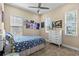 Bright bedroom featuring three windows for natural light, and a bed with blue bedding and a white dresser at 6154 Marsh Trail Dr, Odessa, FL 33556