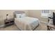 Neutral bedroom featuring a window for natural light, and a bed with patterned bedding and a dark end table at 6154 Marsh Trail Dr, Odessa, FL 33556