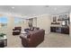 An upstairs bonus room with bar, drink fridge, and comfortable leather seating around a center table at 6154 Marsh Trail Dr, Odessa, FL 33556