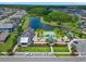An aerial view shows the community pool with palm trees, lounge chairs, and a clubhouse overlooking a pond at 6154 Marsh Trail Dr, Odessa, FL 33556
