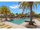 A luxurious community pool features a zero entry, plentiful lounge chairs, palm trees, and a covered seating area at 6154 Marsh Trail Dr, Odessa, FL 33556