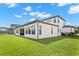 Rear exterior view of a two-story home showcasing lush lawn and screened in pool at 6154 Marsh Trail Dr, Odessa, FL 33556