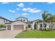 Charming white two-story home featuring a beautiful landscaped yard, tile roof, and two-car garage at 6154 Marsh Trail Dr, Odessa, FL 33556