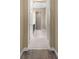 Neutral hallway features tile flooring, arched doorways, and access to other rooms within the home at 6154 Marsh Trail Dr, Odessa, FL 33556