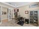 This home office features neutral walls, light carpet, a wooden desk, built-in bookcases and a staircase just through the french doors at 6154 Marsh Trail Dr, Odessa, FL 33556