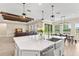 Open-concept kitchen with island seating flows into dining and living area, showcasing modern design at 6154 Marsh Trail Dr, Odessa, FL 33556