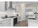Well-equipped kitchen boasts white cabinets, stainless appliances, quartz counters, and wood-look flooring at 6154 Marsh Trail Dr, Odessa, FL 33556