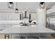 Bright kitchen with white cabinets, stainless steel appliances, large island, and modern pendant lighting at 6154 Marsh Trail Dr, Odessa, FL 33556