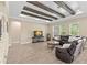 Comfortable living room with beamed ceiling, wood-look tile floors and leather sofa by bright windows at 6154 Marsh Trail Dr, Odessa, FL 33556