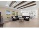 Open-concept living room flows into a kitchen with a beamed ceiling, wood-look tile floors and leather sofa at 6154 Marsh Trail Dr, Odessa, FL 33556