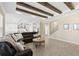 Spacious living room with wood-look tile flooring, coffered ceiling, and a large leather sectional at 6154 Marsh Trail Dr, Odessa, FL 33556