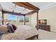 Large, well-lit bedroom with a wooden canopy bed, and nearby entertainment center at 6154 Marsh Trail Dr, Odessa, FL 33556