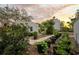 Charming backyard garden with brick pathway, black planters, and lush greenery, perfect for relaxation and outdoor enjoyment at 6251 4Th S Ave, St Petersburg, FL 33707