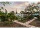 Inviting backyard with a brick pathway, mature mango trees, and a pergola with a covered seating area at 6251 4Th S Ave, St Petersburg, FL 33707