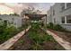 Landscaped backyard features a pergola, brick pathway, and charming garden beds at 6251 4Th S Ave, St Petersburg, FL 33707