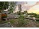 Lush backyard with a wooden swing bench, mature trees, and a garden with a brick pathway at 6251 4Th S Ave, St Petersburg, FL 33707