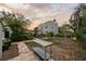 Spacious backyard with a brick path leading to a two-story house, garden area, and mature trees at 6251 4Th S Ave, St Petersburg, FL 33707
