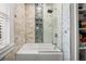 Bathroom featuring white subway tile, glass shower door, built in shampoo shelf, and rain style shower head at 6251 4Th S Ave, St Petersburg, FL 33707