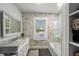Bright bathroom with marble tile, soaking tub, glass shower, and natural light at 6251 4Th S Ave, St Petersburg, FL 33707