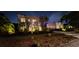 Nighttime view of a stucco two-story house with illuminated landscaping, creating a welcoming ambiance at 6251 4Th S Ave, St Petersburg, FL 33707