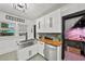 Bright kitchen featuring a stainless steel farmhouse sink, stylish cabinets, butcher block counters, and decorative tile flooring at 6251 4Th S Ave, St Petersburg, FL 33707