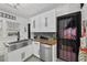 Bright kitchen featuring a stainless steel farmhouse sink, stylish cabinets, butcher block counters, and decorative tile flooring at 6251 4Th S Ave, St Petersburg, FL 33707
