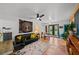 Cozy living room features brick flooring, ceiling fan, black sofa, and office space at 6251 4Th S Ave, St Petersburg, FL 33707