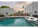 Stunning backyard pool with modern lounge chairs, fenced perimeter, and charming gray-stone architecture at 6251 4Th S Ave, St Petersburg, FL 33707