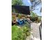 Landscaped backyard featuring blue Adirondack chairs, lounge, and outdoor decor at 6318 Ridge Crest Dr, Port Richey, FL 34668