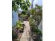 Landscaped backyard with a brick path leading to an outdoor seating area surrounded by lush greenery at 6318 Ridge Crest Dr, Port Richey, FL 34668
