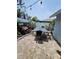 Outdoor patio area with brick pavers, a long table with chairs, and a wooden deck surrounded by plants at 6318 Ridge Crest Dr, Port Richey, FL 34668