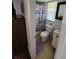 Small bathroom with a toilet, shower with floral shower curtain, tile floors, vanity, and mirror at 6318 Ridge Crest Dr, Port Richey, FL 34668