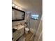 Well-lit bathroom with a white vanity, toilet, shower-tub combo, nautical shower curtain, and tile floors at 6318 Ridge Crest Dr, Port Richey, FL 34668