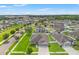 A high aerial view shows the home in a well-planned neighborhood with green lawns and fenced yards at 6670 Paden Wheel St, Zephyrhills, FL 33541