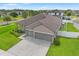 Aerial view showcasing the home's well-maintained landscaping and spacious three-car driveway at 6670 Paden Wheel St, Zephyrhills, FL 33541