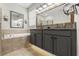Bathroom with a double vanity, large mirrors, a soaking tub, and custom lighting at 6670 Paden Wheel St, Zephyrhills, FL 33541