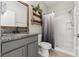 Charming bathroom features a granite countertop, framed mirror, and tiled shower with curtain at 6670 Paden Wheel St, Zephyrhills, FL 33541