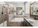 Bathroom showcasing a soaking tub, walk-in shower, and vanity with granite countertops at 6670 Paden Wheel St, Zephyrhills, FL 33541