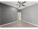 This is a bedroom with gray walls, light colored floors, and a ceiling fan at 6670 Paden Wheel St, Zephyrhills, FL 33541