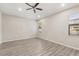 Bedroom with hardwood floors, ceiling fan, and two windows letting in natural light at 6670 Paden Wheel St, Zephyrhills, FL 33541